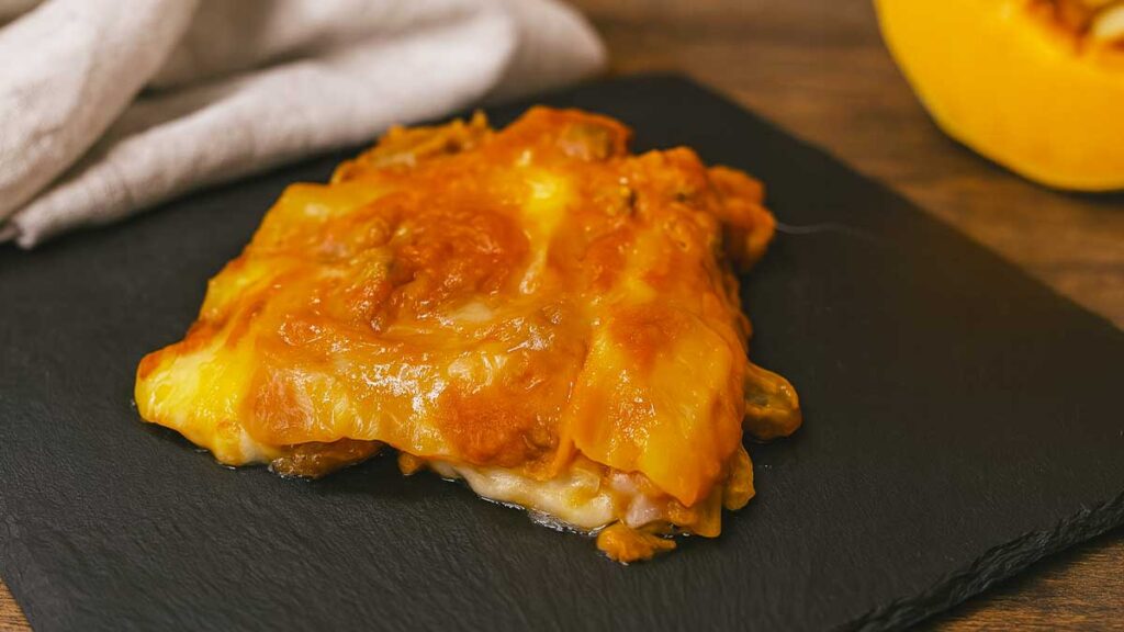 porzione di lasagne alla zucca con salsiccia funghi e provola