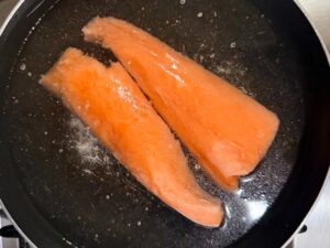 sistema i tranci di salmone in una padella